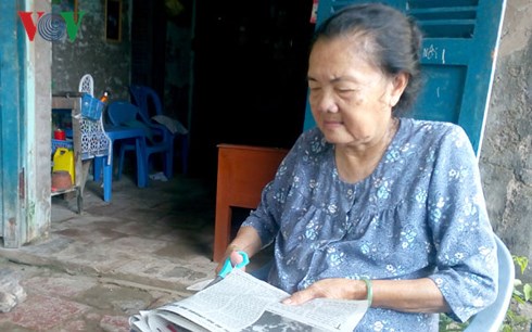 Bà Lê Linh Thìn đang cắt lấy ảnh Bác từ báo