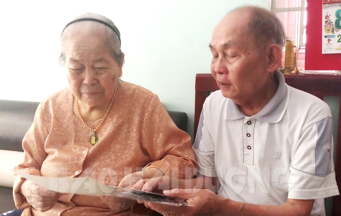 Nghệ sĩ nhiếp ảnh Nguyễn Khuê cùng vợ xem lại những bức ảnh cũ.