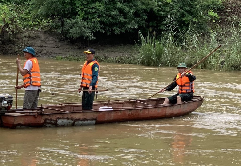 Đồng chí Vương Xuân Nhất (đứng giữa thuyền) trực tiếp tham gia tìm kiếm cứu hộ người mất tích trong mưa lũ.