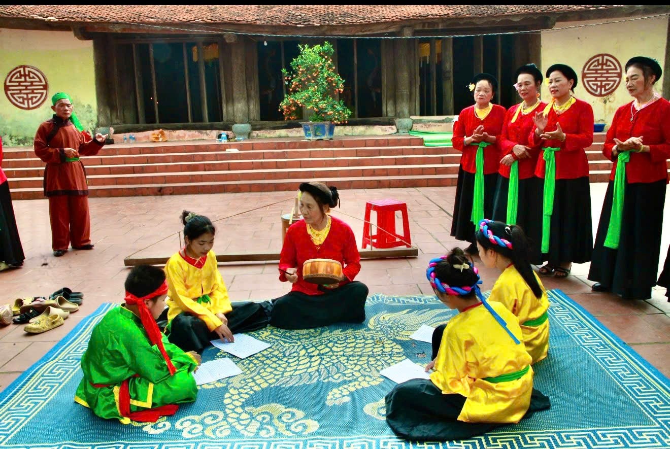 Nghệ nhân ưu tú Kiều Thị Mách truyền dạy các làn điệu trống quân cho thế hệ trẻ. Ảnh: NV