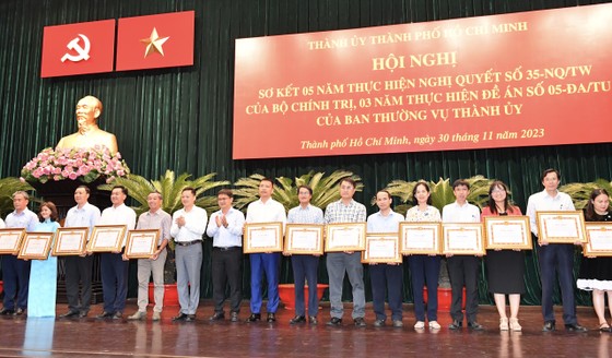Phó Vụ trưởng phụ trách Cơ quan Thường trực Ban Tuyên giáo Trung ương khu vực miền Nam Nguyễn Huy Ngọc và Trưởng Ban Dân vận Thành ủy TPHCM Nguyễn Mạnh Cường trao bằng khen cho các tập thể, cá nhân có thành tích xuất sắc. Ảnh: VIỆT DŨNG
