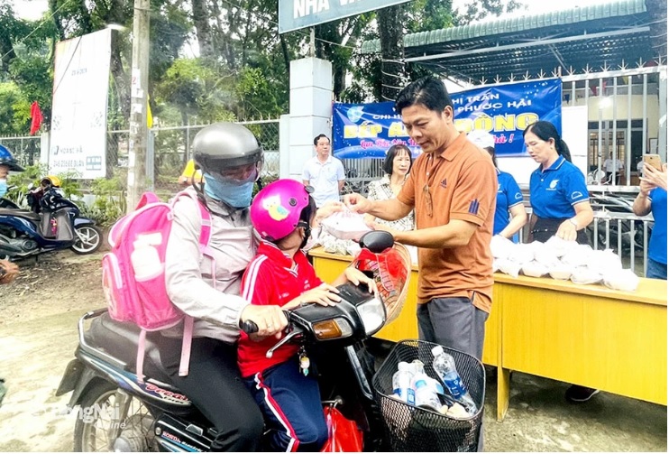 Lãnh đạo TT.Long Thành (H.Long Thành) trao những suất cơm miễn phí cho người dân có hoàn cảnh khó khăn từ mô hình Bếp ăn 0 đồng. Ảnh: T.Lâm